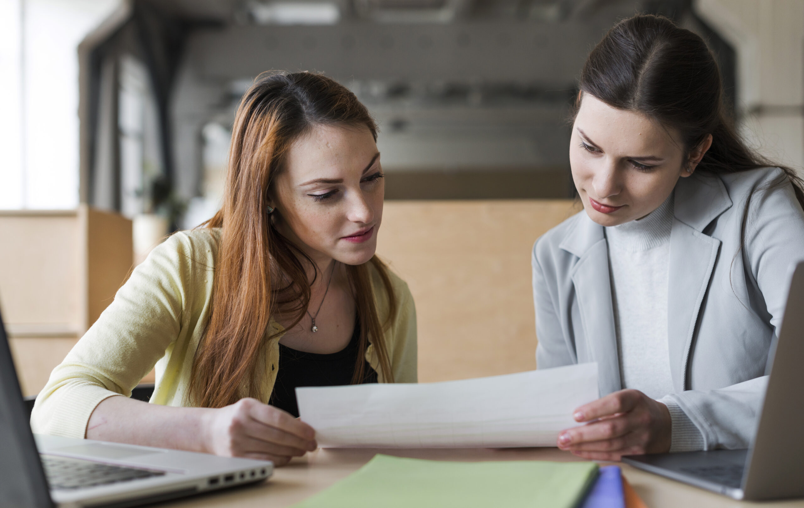 two young businesswoman looking paper office