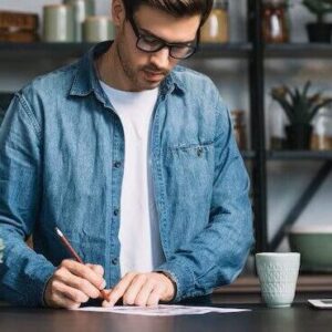 Young Man Standing Kitchen Counter Writing Paper With Pencil 23 2147937150 Edited 2 300x300